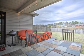 An outdoor patio with a table and chairs, a grill, and a view of a residential neighborhood. - Charming Louisiana Home - 21 Mi to LSU! (Denham Springs)