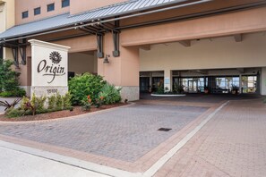 A hotel entrance with a sign reading "Origin 15100" and a paved driveway leading to the entrance. - Origin 803: Gulf-View 1BR w/ Sunset Corner Balcony! (Panama City Beach)