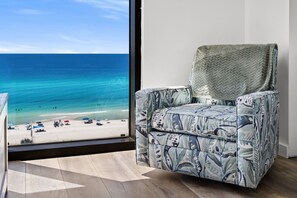 A room with a view of a beach and ocean.