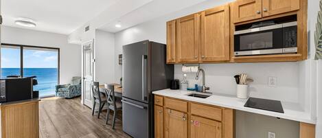 Una cocina moderna con armarios de madera, un refrigerador de acero inoxidable y un microondas.