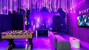 A room with a foosball table, a pool table, and a wall-mounted TV displaying 'AVAT'. - New! Avatar Game Room & Harry Potter Fantasy World (Davenport)