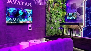 A room with a 'AVATAR' sign, a TV screen, a green wall with plants, and a futuristic design. - New! Avatar Game Room & Harry Potter Fantasy World (Davenport)