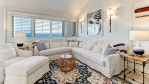 A modern living room with a sectional sofa, a round coffee table, and a patterned rug.