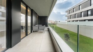 A modern building with a balcony, large windows, and a view of a green area. - GuestReady - Amazing Modern home near the beach (Vila Nova de Gaia)