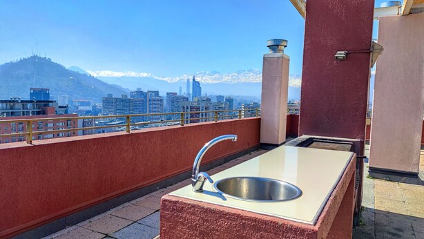 A rooftop terrace with a sink and a view of a cityscape and mountains. - Beautiful apartment, comfortable with excellent location (Santiago)