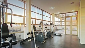 A gym with cardio machines, weightlifting equipment, and large windows. - Beautiful apartment, comfortable with excellent location (Santiago)