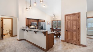 Una cocina amplia con armarios de madera, encimera de granito y microondas integrado.