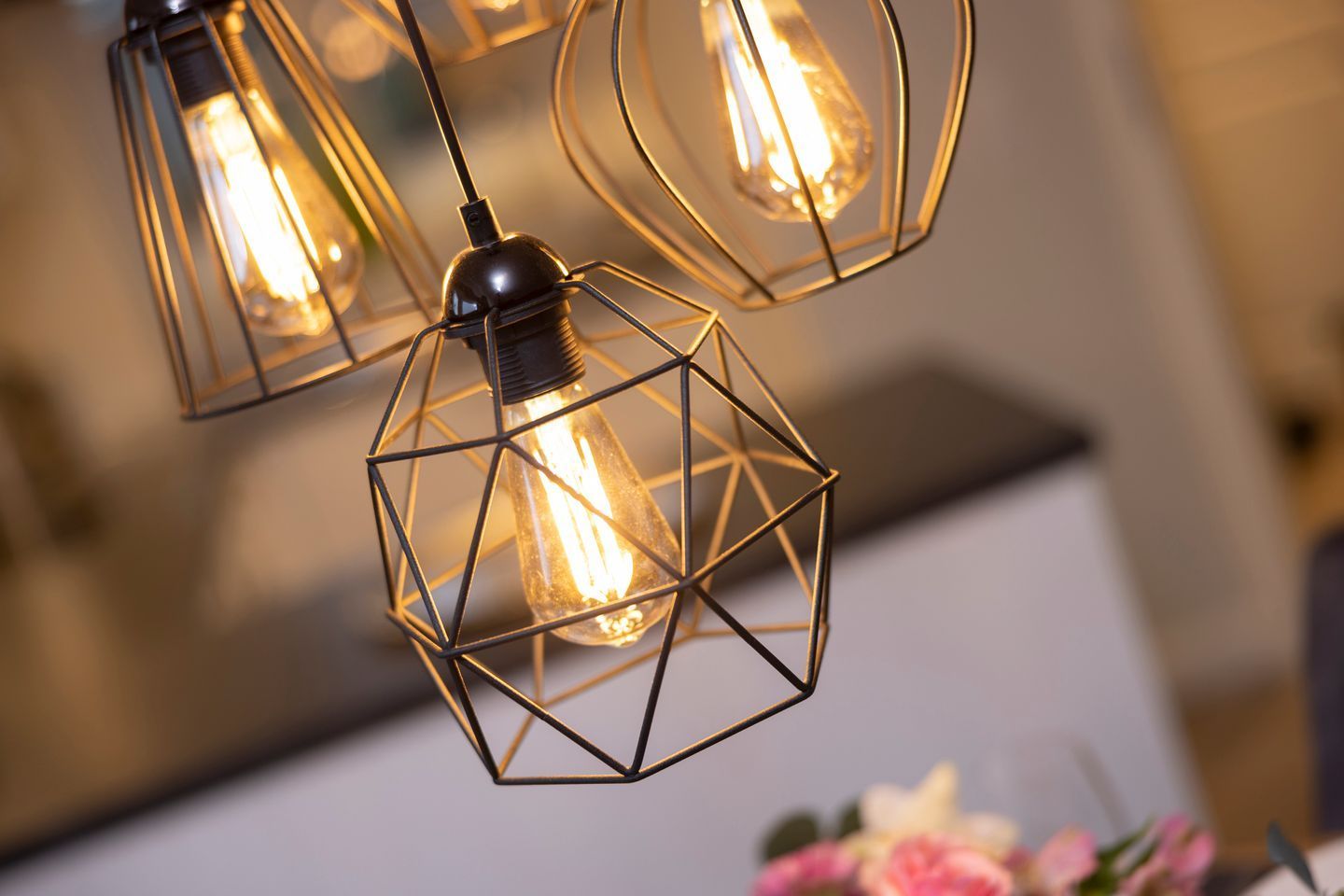 A close-up of a geometric metal light fixture with multiple bulbs.