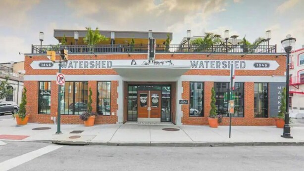 En tvåvåningsbyggnad med namnet ”WATERSHED” tydligt synligt på fasaden.