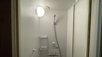 A modern shower with a handheld showerhead and a wall-mounted faucet.