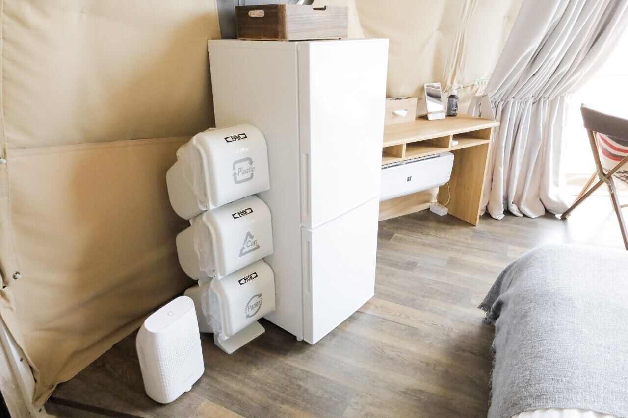 Ein kleines Zimmer mit einem weißen Schrank, einem Schreibtisch und einem Stuhl.