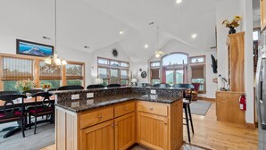 A spacious kitchen with wooden cabinets, granite countertops, and large windows. - 7725- Sun Kissed - Avon Retreat | Pool, Hot Tub & Theater Room (Avon)