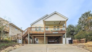 A two-story house with a covered front porch and a garage. - 5176- Sandy Bottoms - Coastal Escape | Dog Friendly + Hot Tub (Kill Devil Hills)
