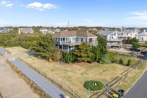 A two-story house with a large deck and a fenced yard.