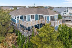 Une propriété en bord de mer, à plusieurs niveaux, dotée de balcons, d’un espace extérieur aménagé et offrant une vue sur les environs.