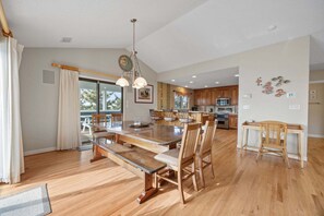 Una cocina moderna con armarios de madera, una isla central e iluminación colgante.