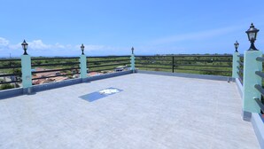 A rooftop terrace with a clear view of the landscape, featuring a railing and street lamps. - RUJIA CONDOTEL CORP. (Lapu-Lapu)