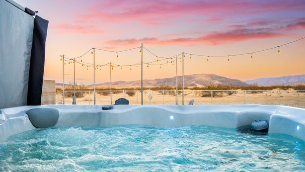 A hot tub with a view of mountains and a sunset. - NEW! HotTub, Hammock, FirePit, BBQ & Paved Driveway (Joshua Tree)