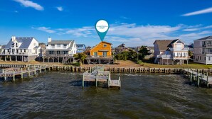 Un quartier résidentiel situé sur la côte, avec des maisons et une jetée qui s’avance dans l’eau.