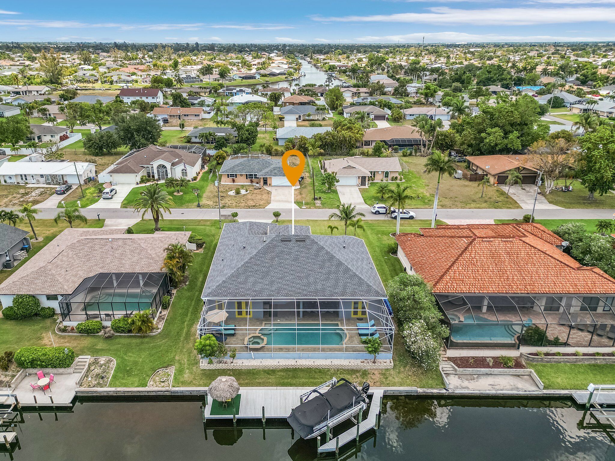 Ett bostadsområde med hus, en swimmingpool och en brygga.
