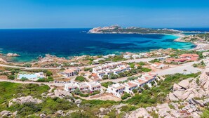 Une ville côtière avec des bâtiments qui bordent la mer, un paysage rocheux et une vue dégagée sur l’océan.