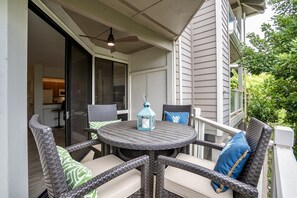An outdoor patio with wicker furniture and a table, a ceiling fan, and a view of the house's interior. - Grand Champions Villas 125, AC, King size Bed, close to Maui's best beaches! (Wailea-Makena)