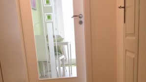 A hallway with a tiled floor leading to a door with a glass panel. - Hotel Flat in the Heart of Prague (Prague)