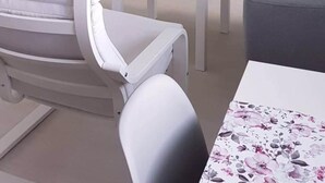 A modern room with a green wall, a white table with chairs, a white sofa, and a painting of purple flowers. - Hotel Flat in the Heart of Prague (Prague)