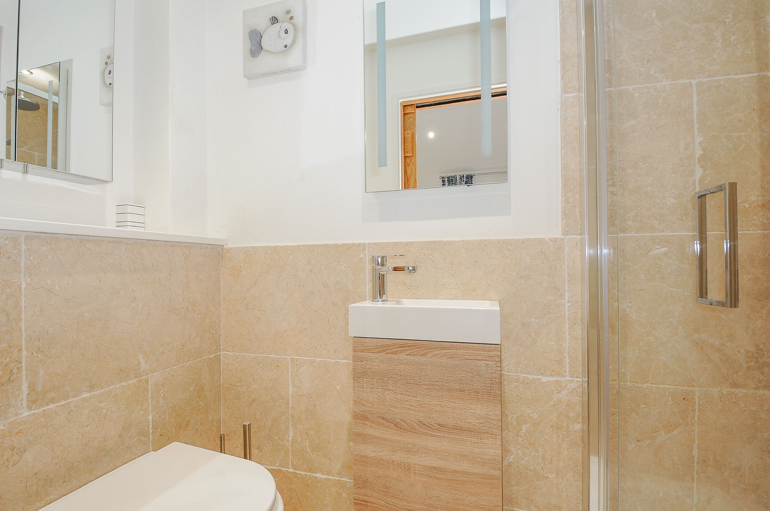 A modern bathroom with a toilet, a sink, and a shower area.
