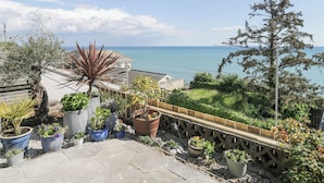 Un jardí al terrat amb plantes en testos i vista al mar.
