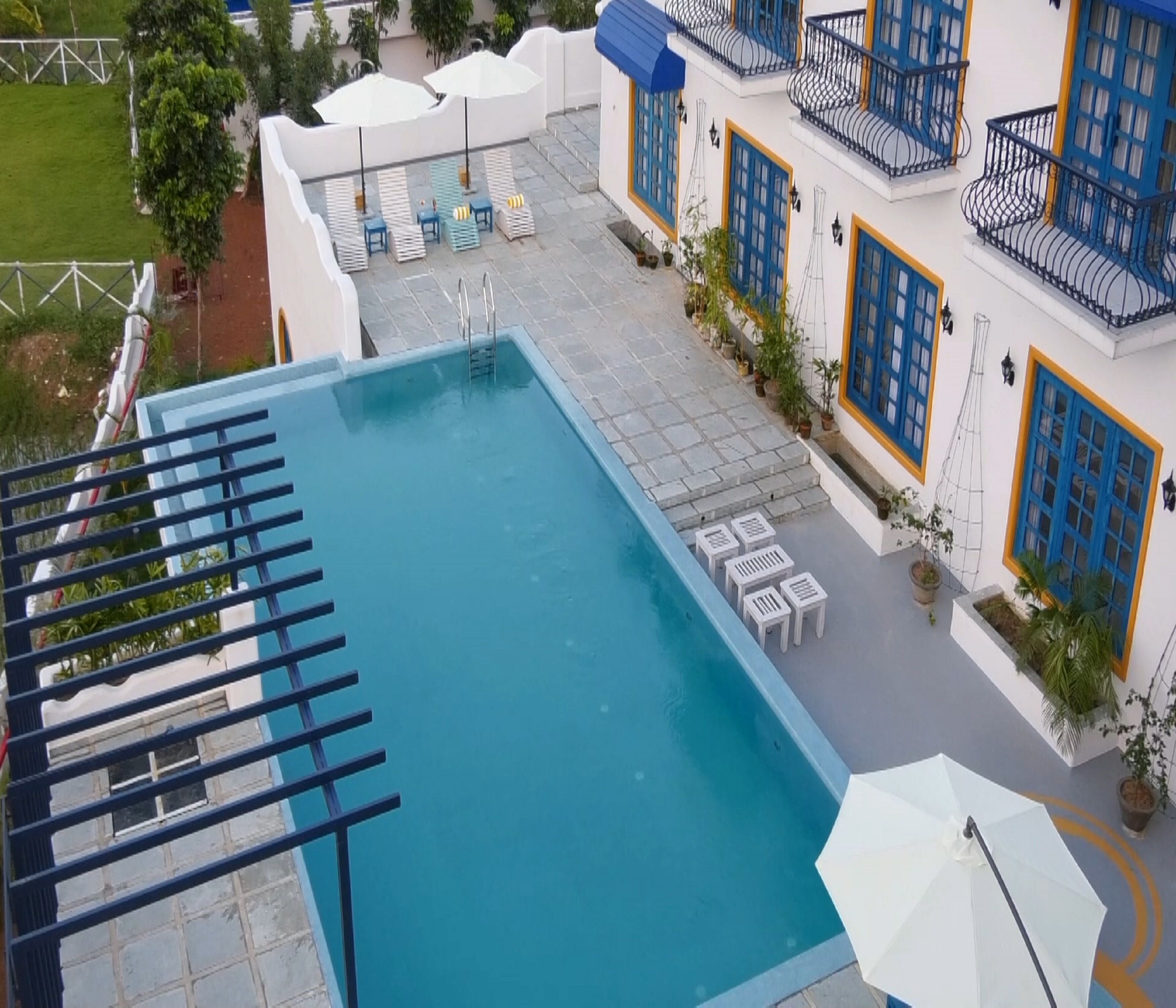 A rooftop pool with a clear view of the surrounding buildings, including a hotel with blue and white exterior and balconies.