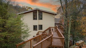 A two-story building with a wooden deck and stairs leading to the entrance. - Mountain Home near Skiing, Hiking, & More (Beech Mountain)
