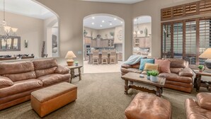 A spacious living room with leather sofas, a coffee table, and a dining area in the background. - Peace in Las Sendas W/ Heated Pool/Spa! 30 night min. (Mesa)