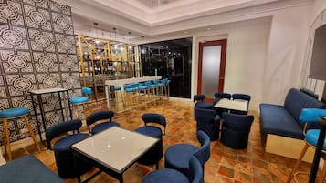A modern restaurant with a bar area, seating arrangements, and a patterned wall.