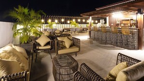 An outdoor seating area with wicker furniture and a bar. - La Casa Blanca de Vigan Hotel (Vigan)