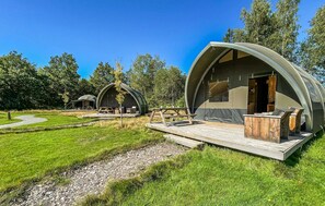 A campsite with dome-shaped tents, picnic tables, and a grassy area. - Awesome (sta)caravan in Hoogersmilde (Hoogersmilde)