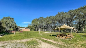 A campsite with a tent, picnic tables, and a barn in the background. - Awesome (sta)caravan in Hoogersmilde (Hoogersmilde)
