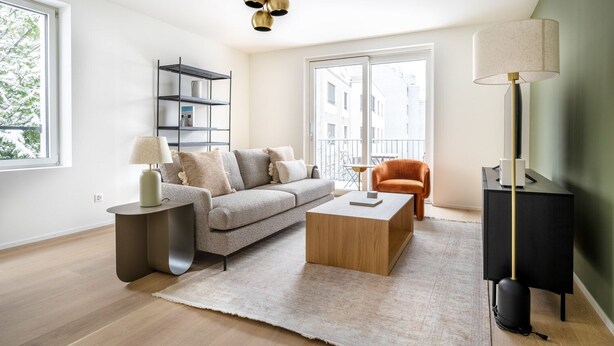 Un salon moderne avec un canapé, une table basse et un meuble pour la télévision.