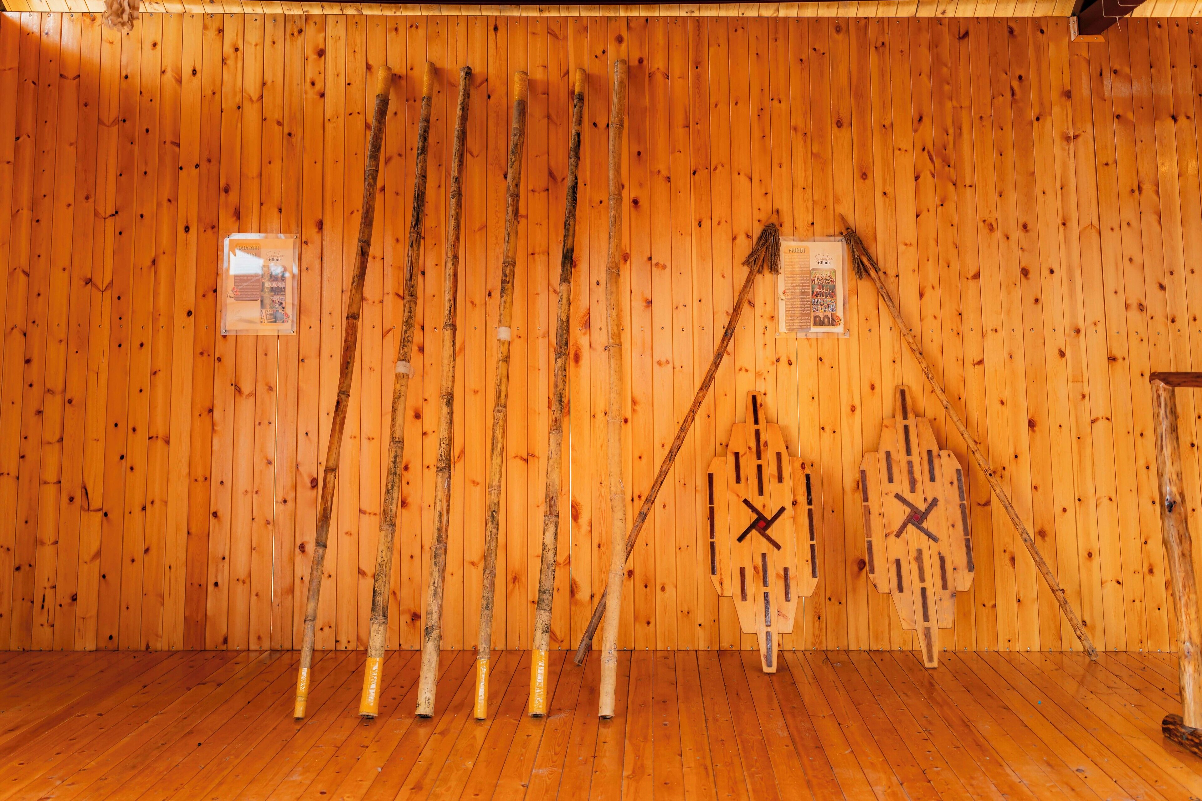 Ein Zimmer mit Holzwänden und Holzböden, mit einer hölzernen Wanduhr und mehreren Holzstücken, die an der Wand lehnen.