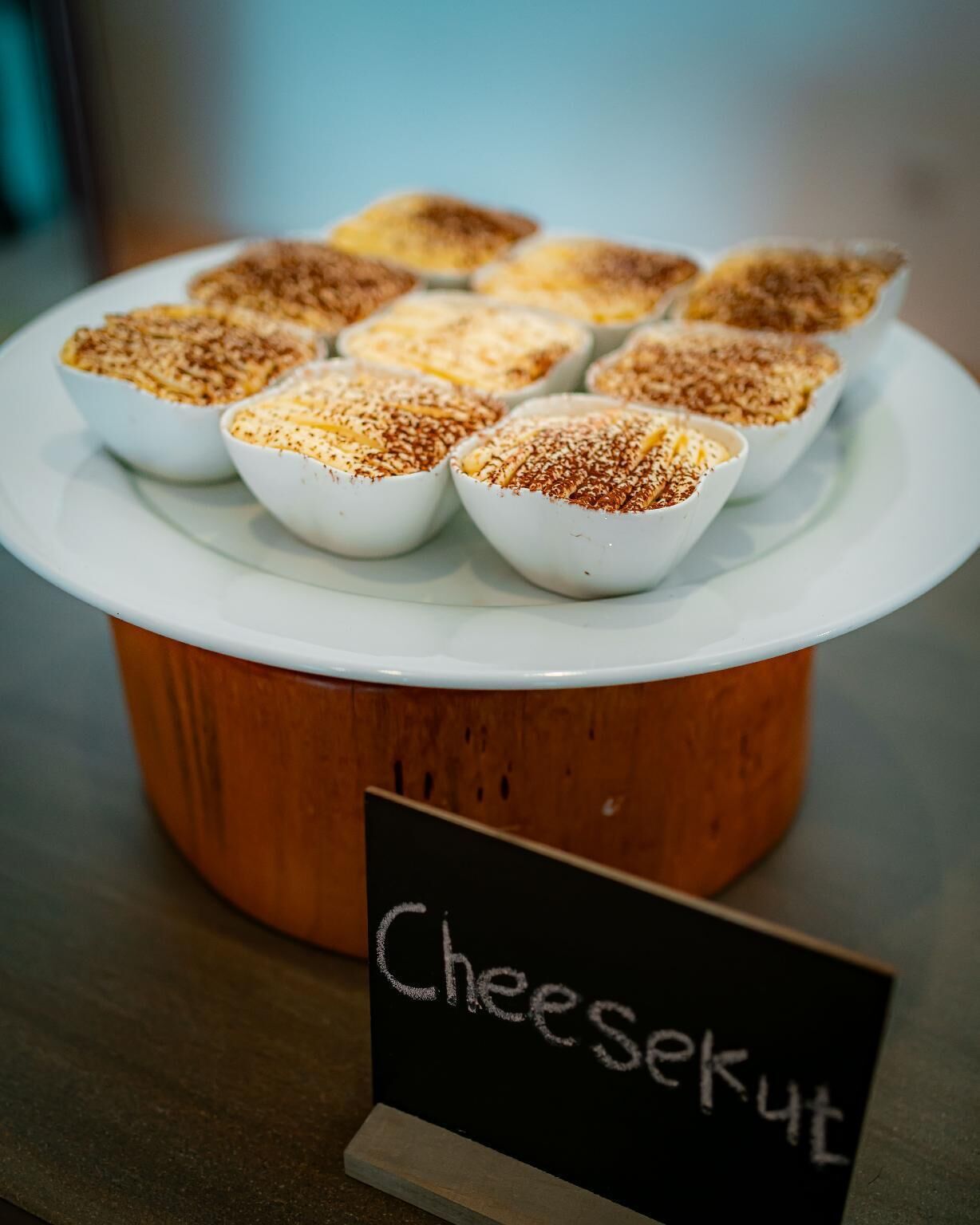 A display of cheese cups on a white plate with a sign labeled "Cheesekut".