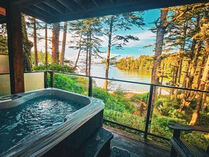 A hot tub with a view of a lake and forest.