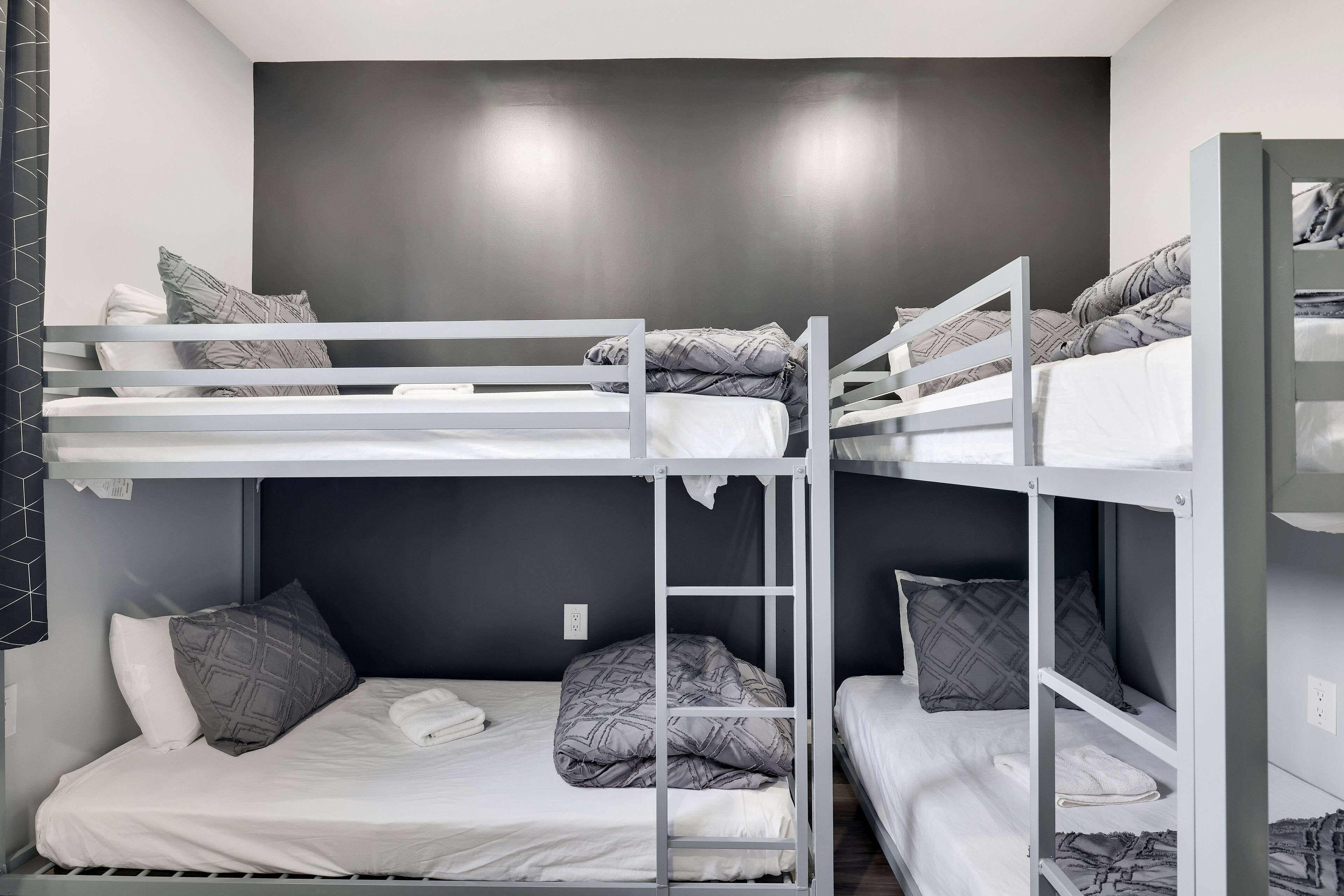 Habitación con literas, dos camas, cada una con almohadas y una manta.