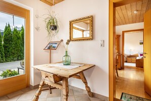 A wooden desk with a vase, a framed picture, and a mirror on the wall. - Holiday Apartment "Wesseling" with Mountain View, Private Terrace & Wi-Fi (Fontanella)