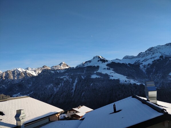A mountain landscape with snow-covered peaks and a clear sky.