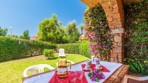 An outdoor dining area with a table set for two, featuring a pitcher, glasses, and a cup. - 2 bedroom beautiful apartment in San Teodoro (San Teodoro)