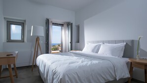 A bedroom with a bed, a desk, a lamp, and a view of the outdoors. - Luxurious Sea View Villa in Agios Nikolaos (Agios Nikolaos)