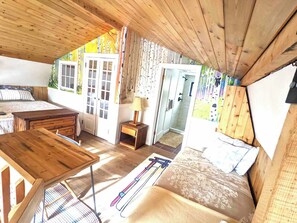 A cozy cabin with a wooden interior, a bed, a desk, and a small bathroom. - The Snow Shack 2BR w Hot Tub, Stream, Fireplace, Steam Rm on 5 Acres Near Breck (Alma)