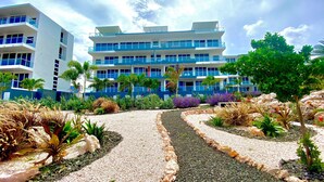 Un hôtel à plusieurs étages, doté d’une façade bleue et blanche, de sentiers extérieurs et de jardins aménagés.