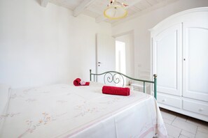Un dormitorio con cama, armario y puerta que da a otra habitación.
