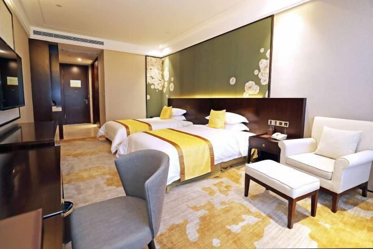 Een hotelkamer met een groot bed, een bureau, een stoel en een bank.